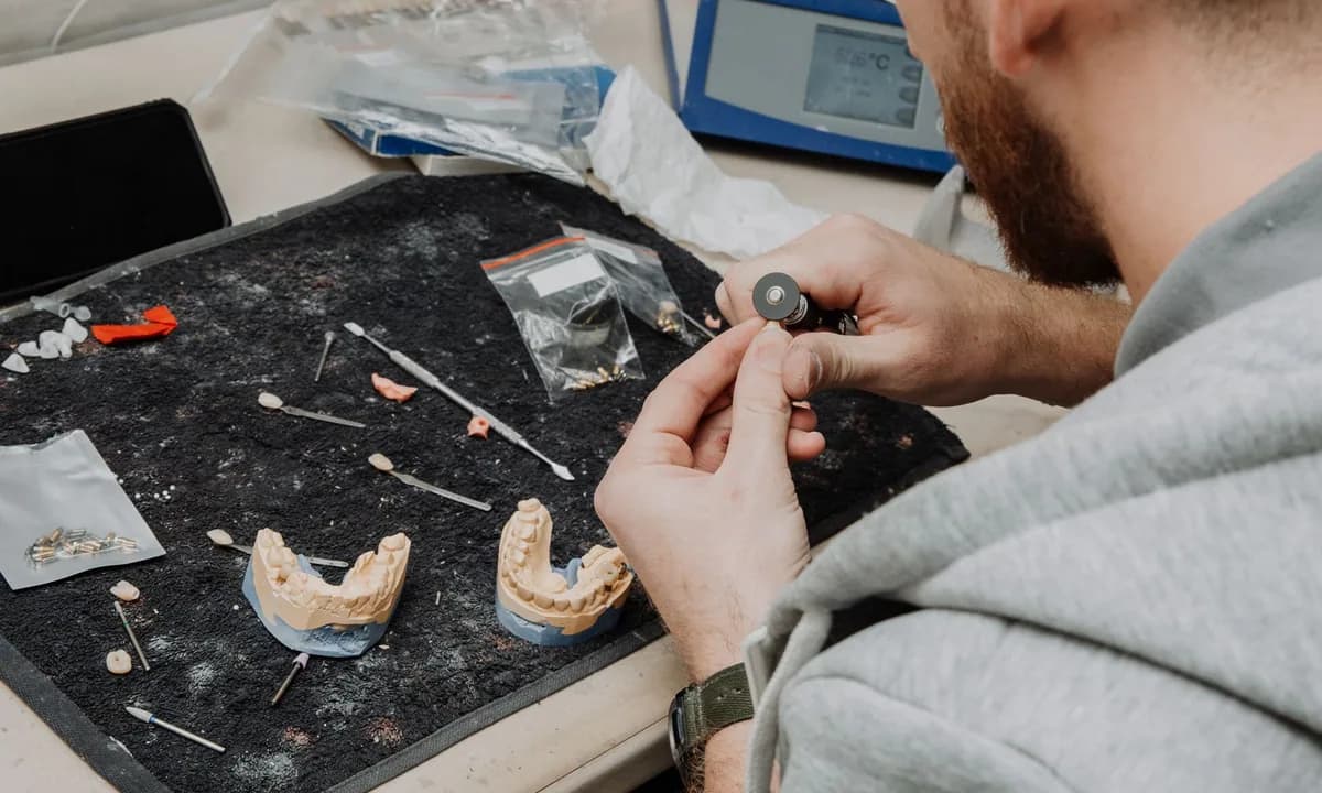 Laboratuvar masasında dental model üzerinde çalışan teknisyen