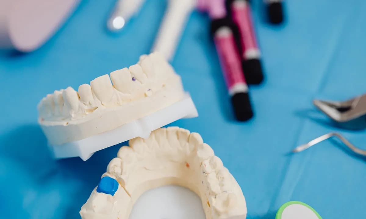 Mavi masa üzerinde iki dental model ve el aletleri