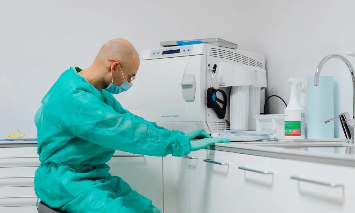 Dental laboratuvar cihazlarını çalışma masasında kullanan teknisyen